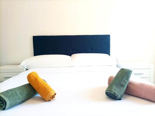 a bed with four different colored towels on it at El Cabanyal 400m from the Beach in Valencia
