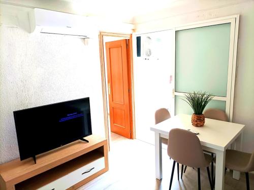 a living room with a tv and a table with chairs at El Cabanyal 400m from the Beach in Valencia