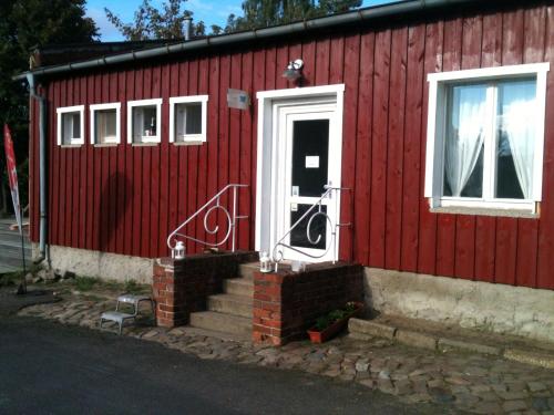 a red house with a white door and stairs outside at Wassersportzentrum Alte Feuerwache in Brandenburg an der Havel