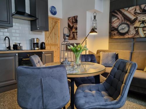 a kitchen and living room with a table and chairs at Szarotka II in Szczecin