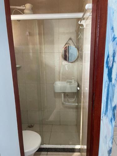 a small bathroom with a toilet and a sink at Hospedagem Por do sol in Arraial do Cabo