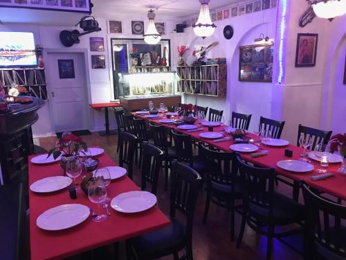 a long table in a restaurant with red tables and chairs at HotelPandekagehuset B&B in Nykøbing Sjælland