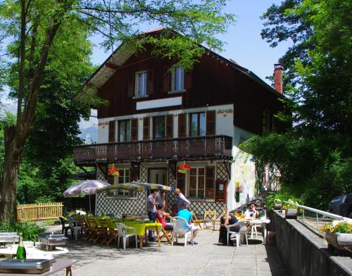 un grupo de personas sentadas fuera de un edificio en Gîte Mont Joly, en Saint-Gervais-les-Bains