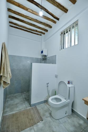 a white bathroom with a toilet in a room at Apartment Kiwengwa in Kiwengwa