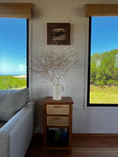 a living room with a couch and a vase on a table at Casa Grande Punta del Diablo in Punta Del Diablo