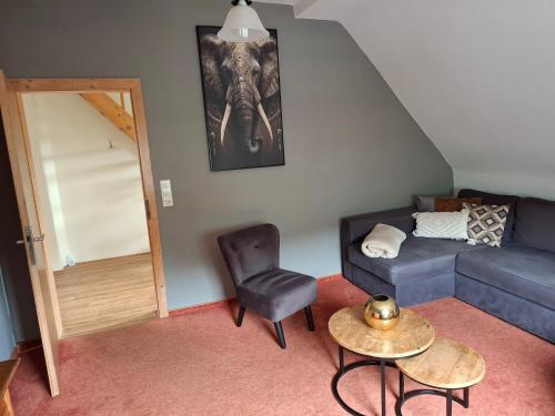 a living room with a blue couch and a chair at Ferienhaus in Willingen mit eigenem Garten in Willingen