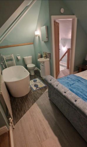 a bedroom with a bed and a tub and a sink at Beach house Mablethorpe Stylish Spacious, 2 bedrooms sleeps 6 200m to beach in Mablethorpe