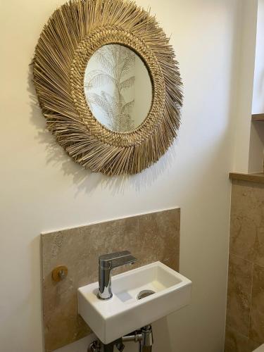 une salle de bain avec un lavabo et un miroir au mur dans l'établissement Villa Palmeira- Sainte-Maxime, à Sainte-Maxime