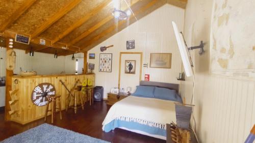 Un dormitorio con una cama y una mesa y sillas. en Departamento Refugio Compinches, Castro Chiloé, en Tentén