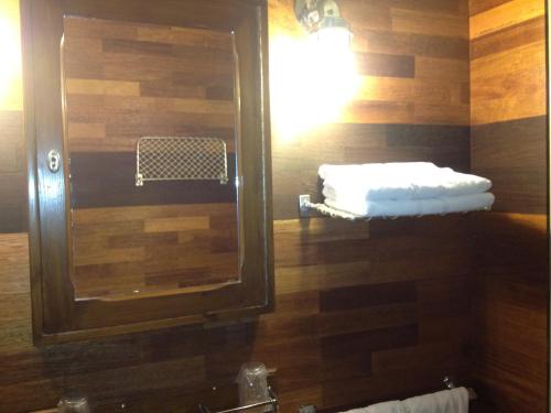 a bathroom with a mirror and a sink with towels at Hôtel Kermor in Concarneau