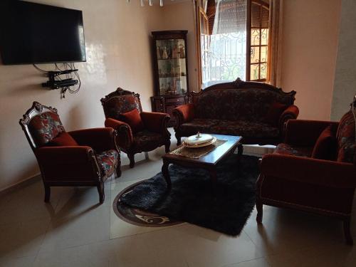 a living room with couches and chairs and a table at Villa avec piscine à ORAN in Oran
