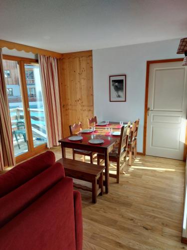 Le MélézetにあるAppartement les orres 1800のダイニングルーム(テーブル、赤いソファ付)