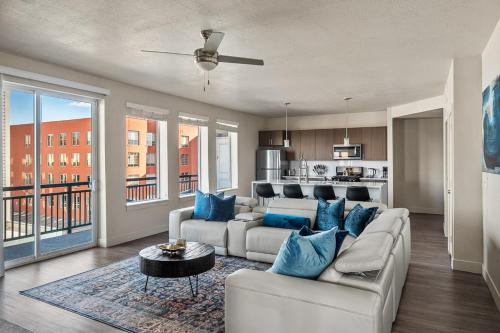 a living room with a white couch and blue pillows at Gorgeous 2BD 2BA Pool,Gym,Htub near Convention Ctr in Salt Lake City