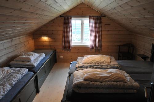 una stanza con tre letti in una mansarda di Løstegård Cabins a Gol