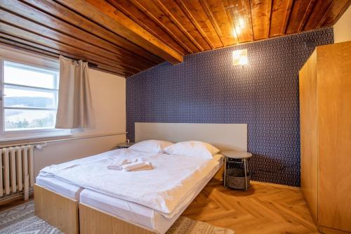 a bedroom with a bed with a robe on it at Aparthotel Panorama in Deštné v Orlických horách
