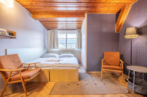 a small bedroom with a bed and two chairs at Aparthotel Panorama in Deštné v Orlických horách