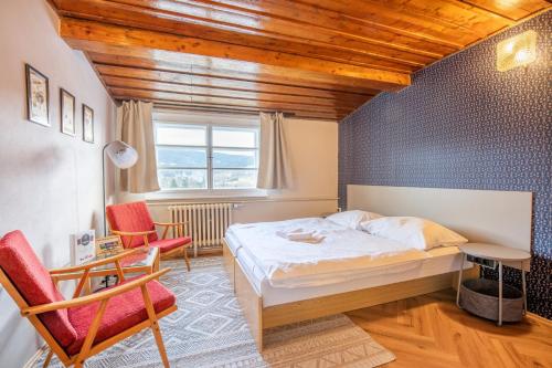 a bedroom with a bed and a desk and chairs at Aparthotel Panorama in Deštné v Orlických horách