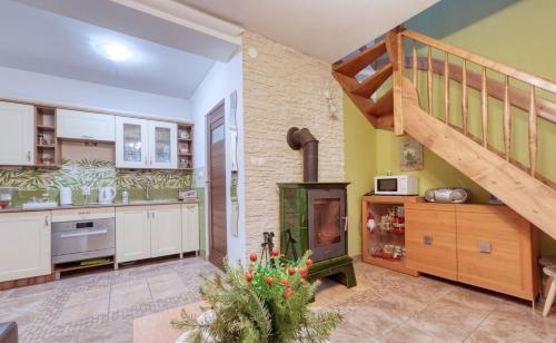 a kitchen with a staircase and a kitchen with a fireplace at Nowy Domek Pod Kogutkiem in Górki Wielkie