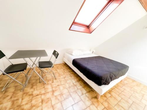 a bedroom with a bed and a table and a window at Anh Dao 3 - Studio, centre ville, tiamconciergerie in Champs-Sur-Marne