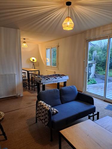 - un salon avec un canapé et une table de ping-pong dans l'établissement Gîte L'étape 6 chambres, à Redon