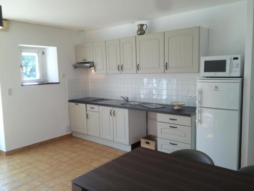 une cuisine avec des armoires blanches et un réfrigérateur blanc dans l'établissement Farmhouse in an amazing private park, à Vannes