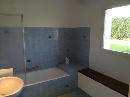une salle de bain avec une baignoire et un lavabo dans l'établissement Farmhouse in an amazing private park, à Vannes