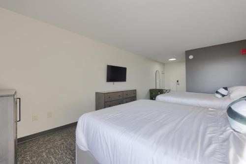 a bedroom with a white bed and a flat screen tv at Lititz Pointe Inn and Suites in Lititz