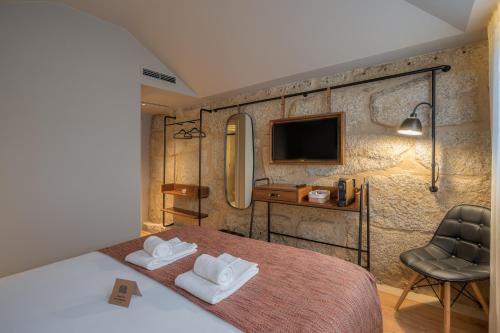 a bedroom with a bed and a desk and a tv at Carpe Diem Porto By Dualhotels in Porto
