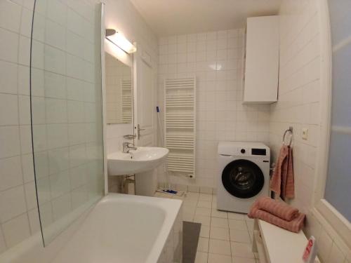 une salle de bain avec une machine à laver et un lavabo dans l'établissement Apartment near Paris by metro, à Saint-Denis