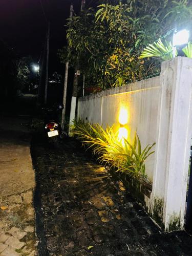 a fence with a light on the side of it at Nisha Grean Heaven in Weligama