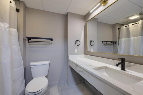 a bathroom with a toilet and a sink and a mirror at Lititz Pointe Inn and Suites in Lititz