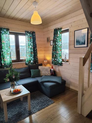 un soggiorno con un divano e un tavolo di Leśna Przystań - Domki całoroczne a Grywałd