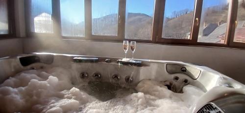 a bath tub covered in snow with two champagne glasses at Pensiunea Carmen in Bucium