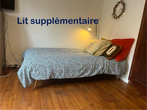 a bed in a room with a sign that reads lift supplementitute at Maison Périgord vert piscine et spa in La Roche-Chalais