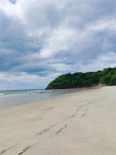 a beach with footprints in the sand on a cloudy day at Apartamento El palmar frente al mar in Las Palmeras