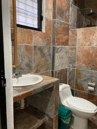 a bathroom with a toilet and a sink at Las Olas in Puerto Escondido