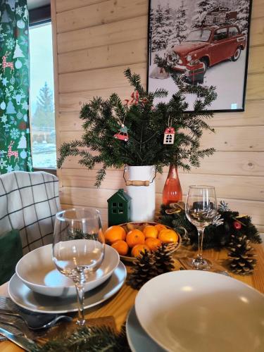 una mesa con dos copas de vino y naranjas. en Leśna Przystań - Domki całoroczne, en Grywałd