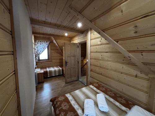 a log cabin with a bed in a room at Witowianskie Domki Private Jacuzzi & Mountain View near Zakopane in Dzianisz