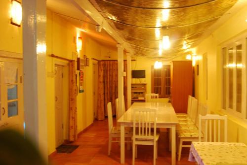 a dining room with a white table and chairs at Bella Vista Homestay in Coonoor