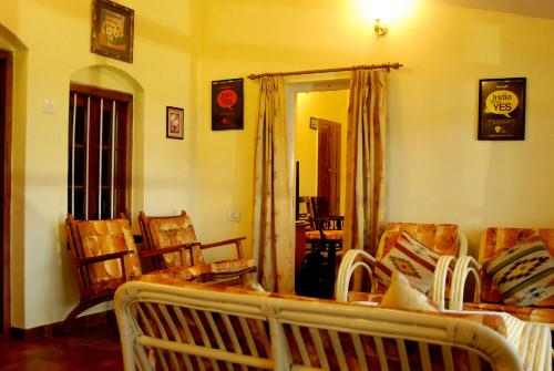 a living room with a couch and chairs and a mirror at Bella Vista Homestay in Coonoor