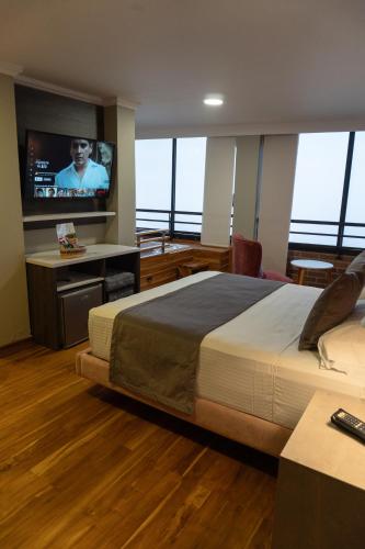 a hotel room with a bed and a flat screen tv at Hotel Entre Brumas in Aguadas