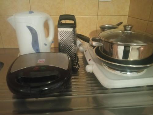 a stove top with a pot and a pan on it at George Studios Stalis in Stalida