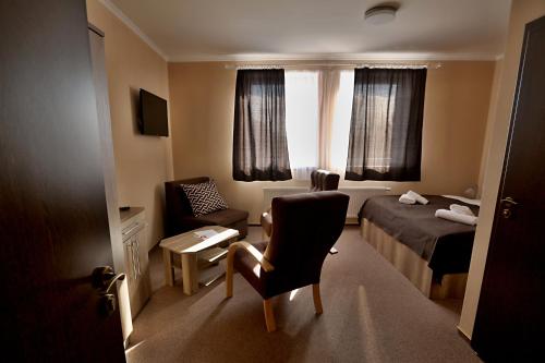 ein Hotelzimmer mit einem Bett und einem Stuhl in der Unterkunft Pension Viola in Domažlice