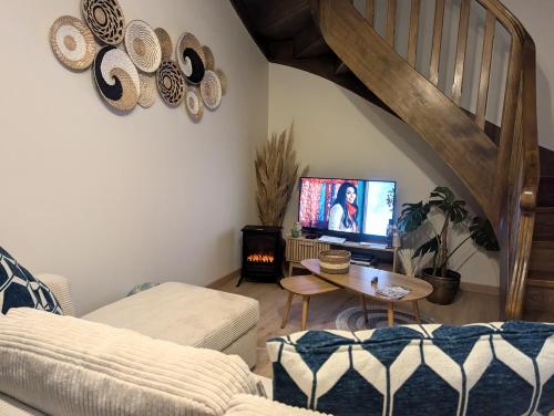 a living room with a couch and a table with a tv at L'Atelier des Rêves in Saverne