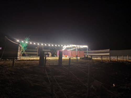 a fence with lights in a field at night at ROYAl FINS CAMP in Fins