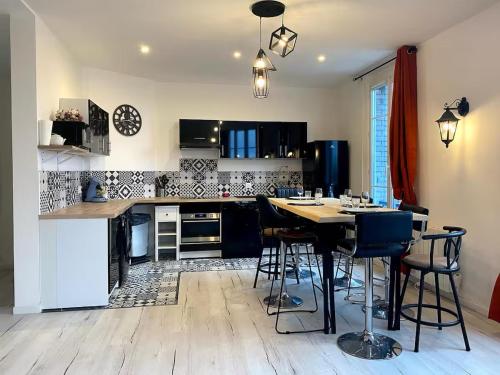 une cuisine avec une table et quelques chaises dans l'établissement T5 - Aéroport CDG - Parc des Expositions Villepinte, à Aulnay-sous-Bois