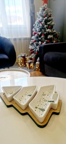 two serving dishes on a table in front of a christmas tree at Modern Mountain in Kolašin