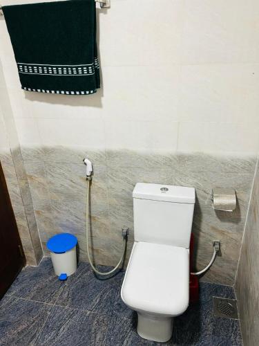 a bathroom with a toilet and a green towel at Nisha Grean Heaven in Weligama