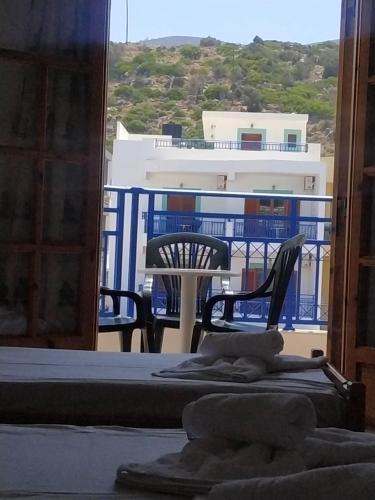 a room with a bed and a balcony with a building at George Studios Stalis in Stalida