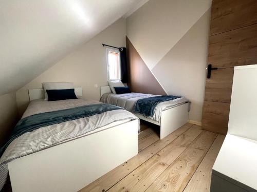 - 2 lits dans une petite chambre dotée de parquet dans l'établissement Gîte Ancien Atelier - chemin de halage, à Muides-sur-Loire